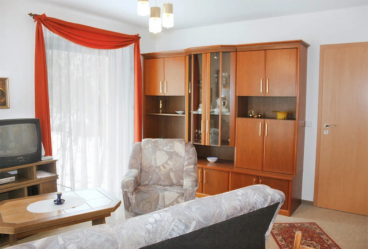 Wohnstube der Wohnung 3 mit Sitzgruppe und Schrankwand